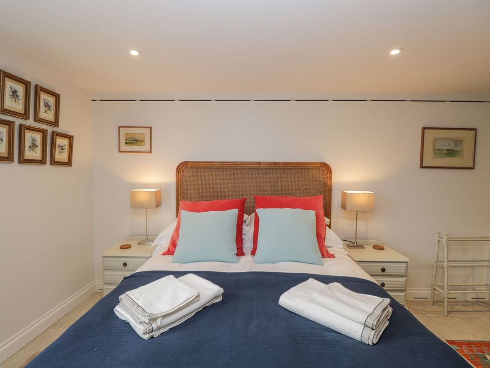 A bedroom with a bed and wall art at The Old Swill House in Foxham