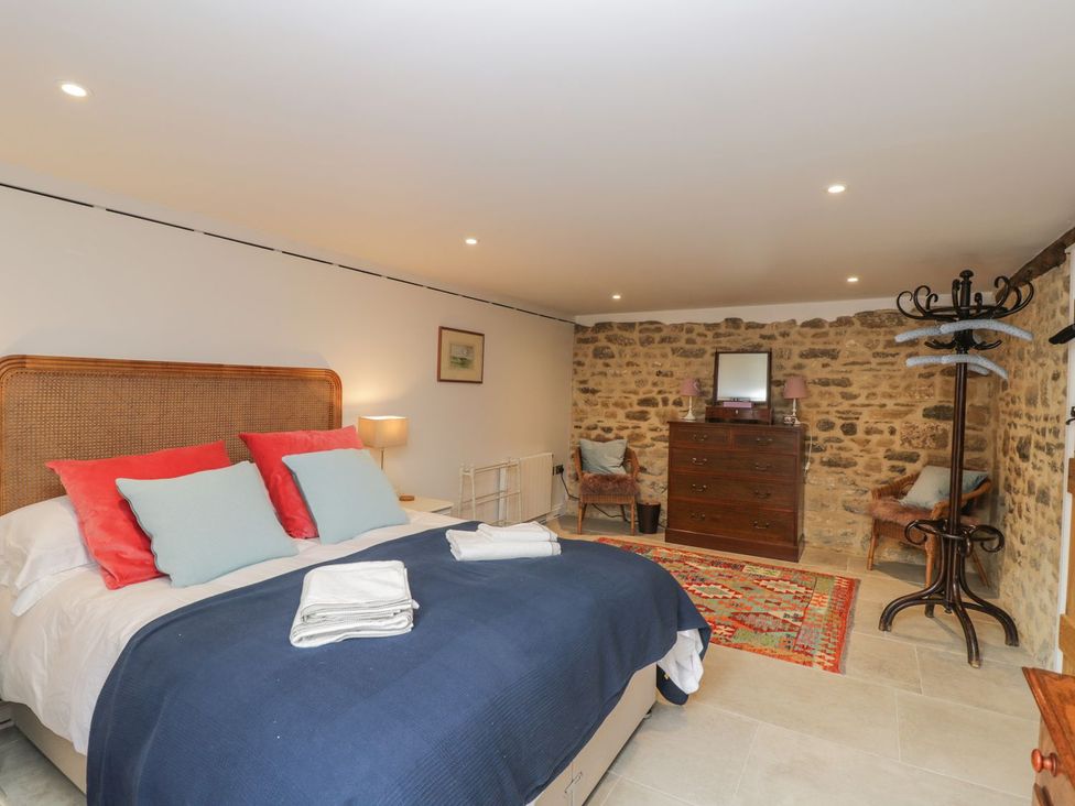 A bedroom with a bed and dresser at The Old Swill House in Foxham