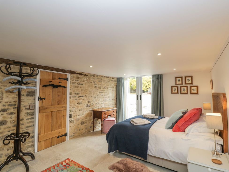 A bedroom with a bed and coatrack at The Old Swill House in Foxham