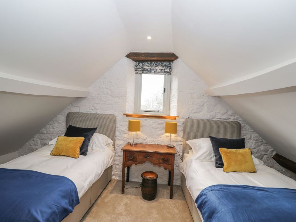 A bedroom with two beds and a table at The Old Swill House in Foxham