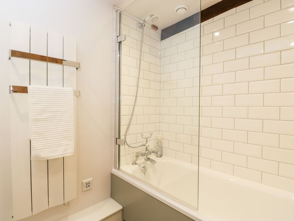A bathroom with a bathtub and shower area at The Old Swill House in Foxham