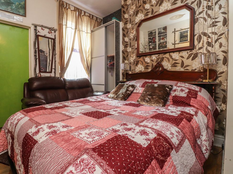 A bedroom with a bed and sofa at Number 2 in Blackpool