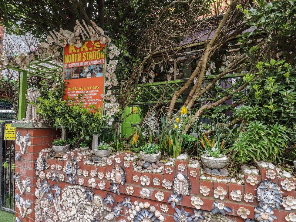 A garden with decorative stones and a sign at K.K.'s North Station in Blackpool