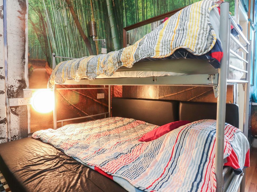 A bunk bed with striped bed linens at Number 6 Blackpool