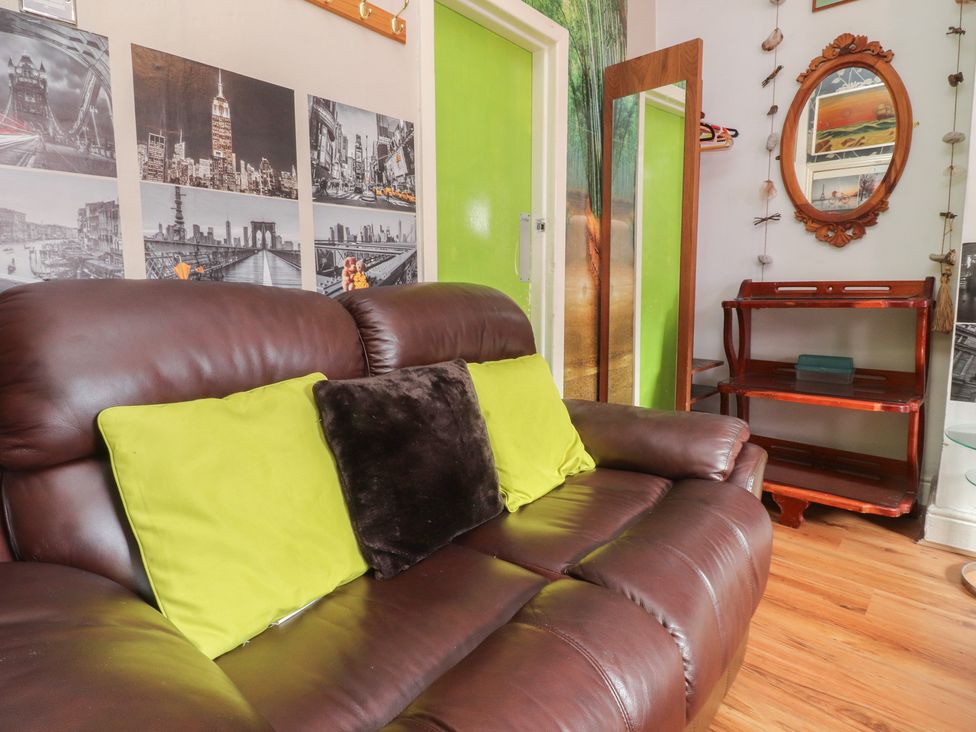 A living room with a brown sofa and green cushions at Number 6 Blackpool