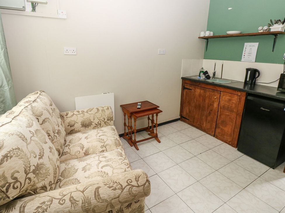 A kitchen with a sofa and coffee table at Cabin No. 15 - Salt and Fern Cabins Goytre near Port Talbot