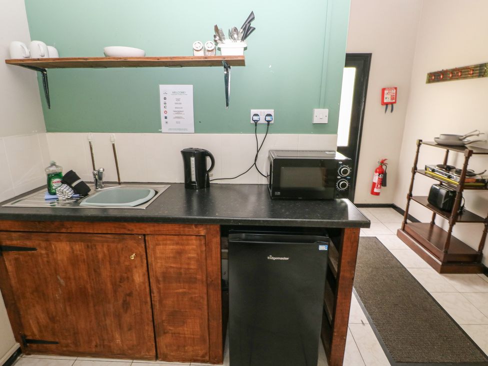 A kitchen with sink, fridge, kettle, and microwave at Cabin No. 15 - Salt and Fern Cabins Goytre near Port Talbot