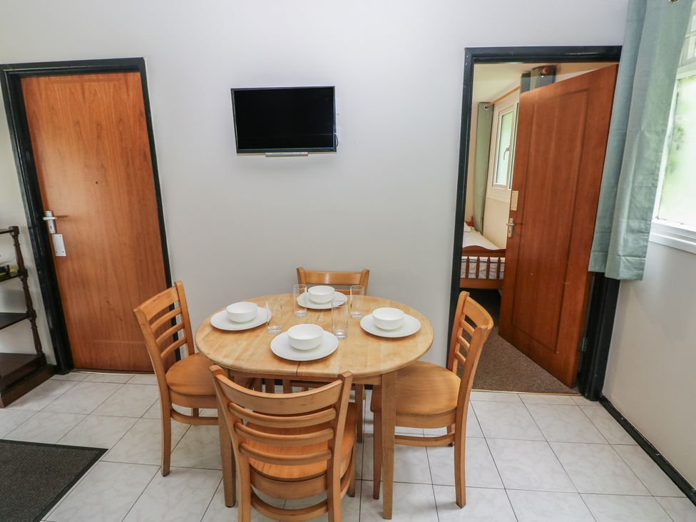 A dining room with a table and chairs at Cabin No. 15 - Salt and Fern Cabins Goytre near Port Talbot