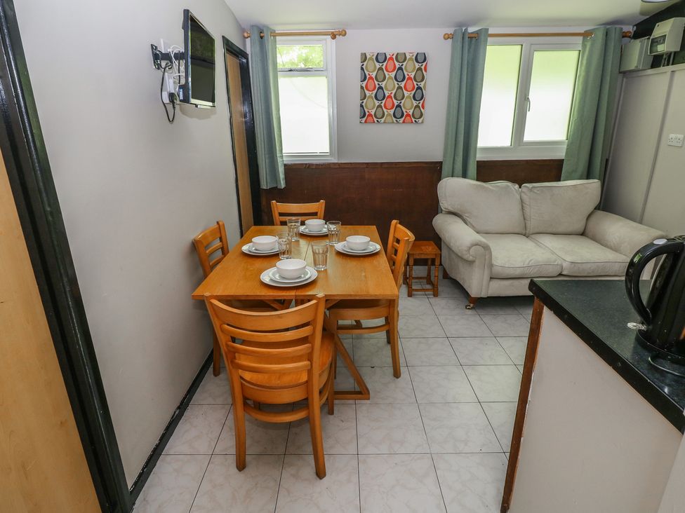 A dining room with a table and chairs at Cabin No. 16 - Salt and Fern Cabins Goytre near Port Talbot
