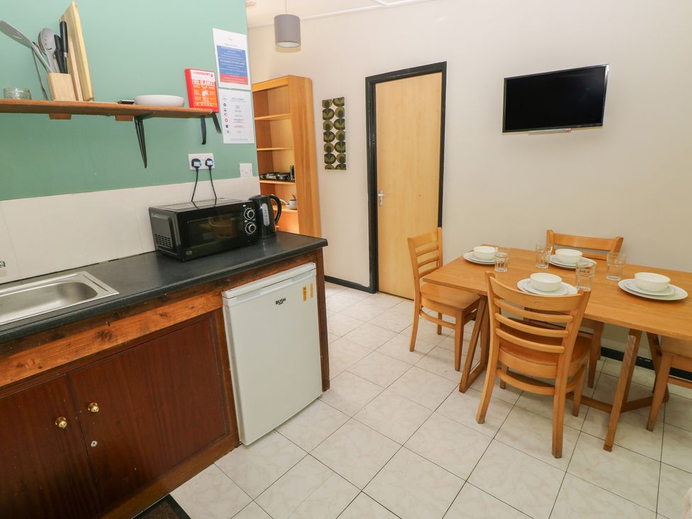 A kitchen with dining table and appliances at Cabin No. 16 - Salt and Fern Cabins Goytre near Port Talbot