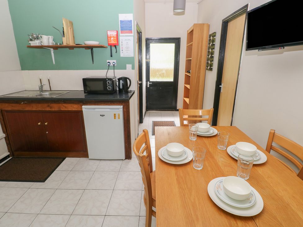 A kitchen with a dining table and chairs at Cabin No. 16 - Salt and Fern Cabins Goytre near Port Talbot
