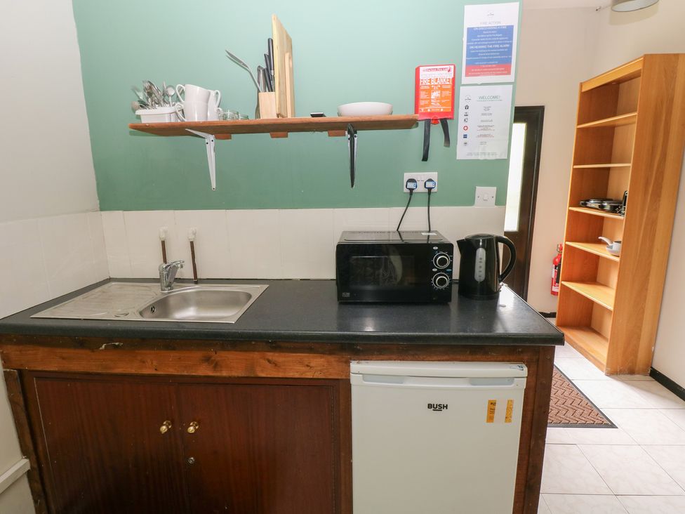 A kitchen with a sink, microwave, and kettle at Cabin No. 16 - Salt and Fern Cabins Goytre near Port Talbot