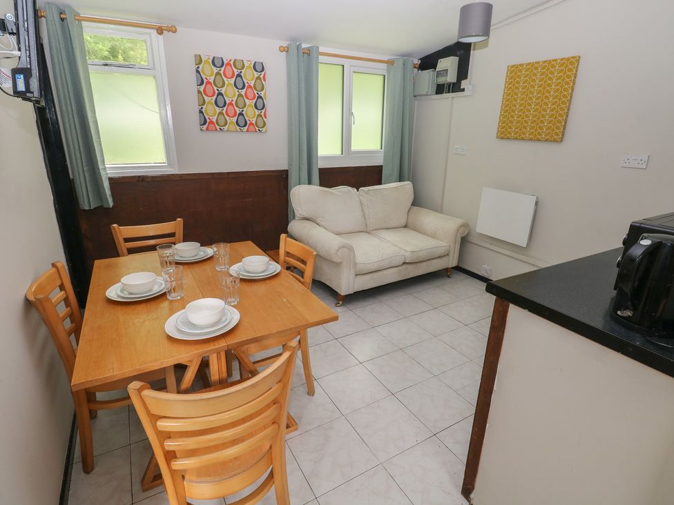 A living room with a dining table and couch at Cabin No. 16 - Salt and Fern Cabins Goytre near Port Talbot
