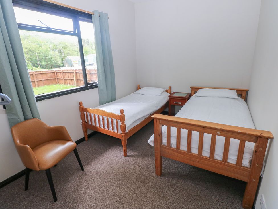A bedroom with two beds and a chair at Cabin No. 16 - Salt and Fern Cabins Goytre near Port Talbot