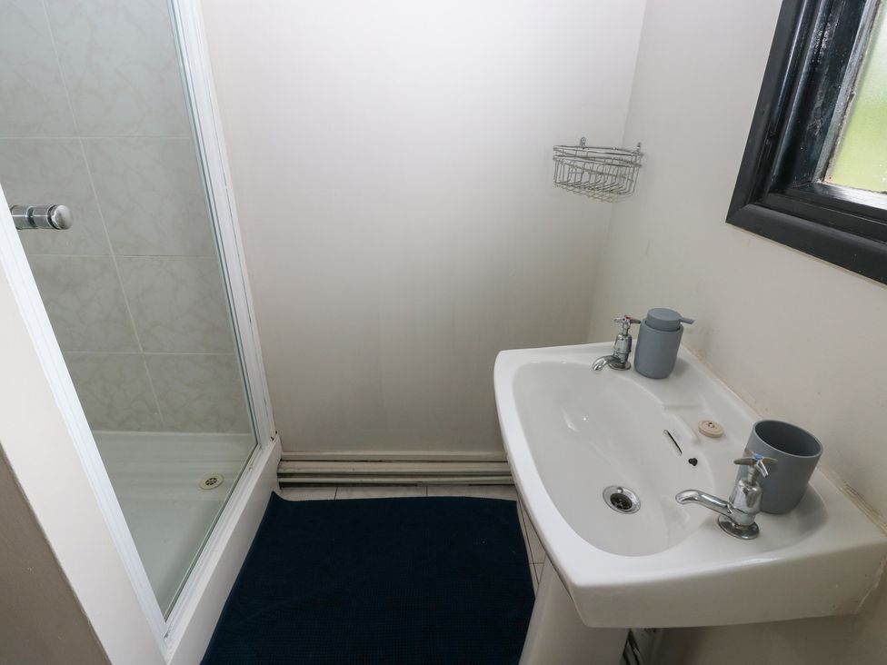 A bathroom with a shower and sink at Cabin No. 16 - Salt and Fern Cabins Goytre near Port Talbot