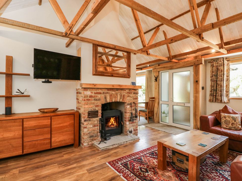 A living room with a fireplace and television at Little Orchard in SwallowCliffe
