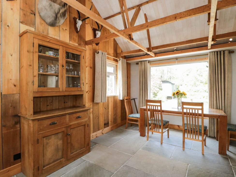A dining room with a wooden table and chairs at Little Orchard in SwallowCliffe