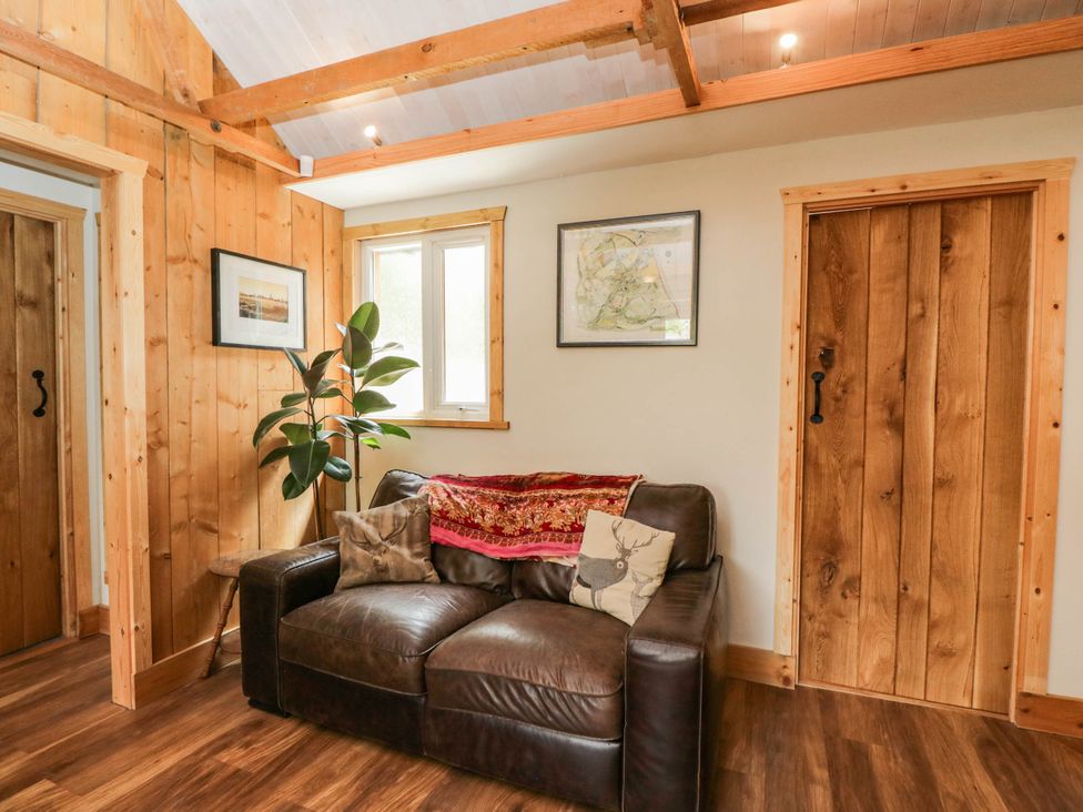 A living room with a sofa and a plant at Little Orchard in SwallowCliffe