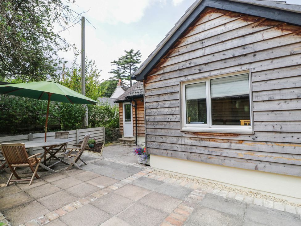 A garden with patio furniture and a wooden shed at Little Orchard, SwallowCliffe