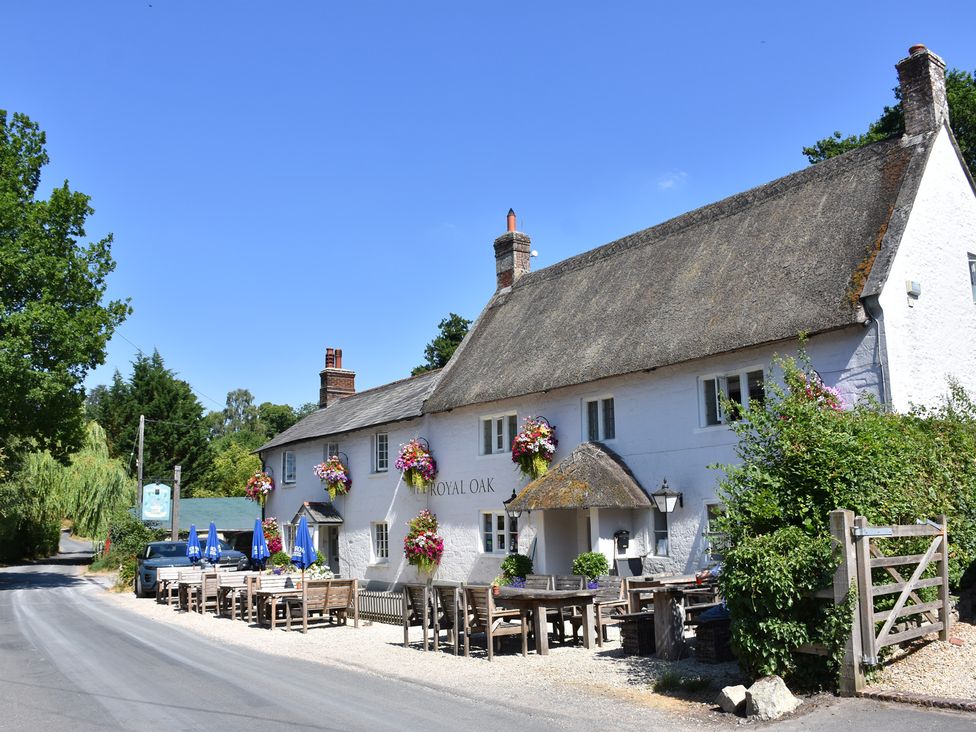 A pub with outdoor seating and tables at The Royal Oak in SwallowCliffe