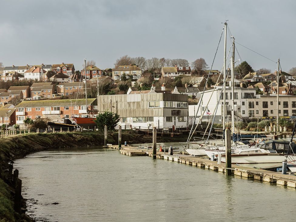 A marina with boats and buildings at 5 Mariners Wharf in Newhaven