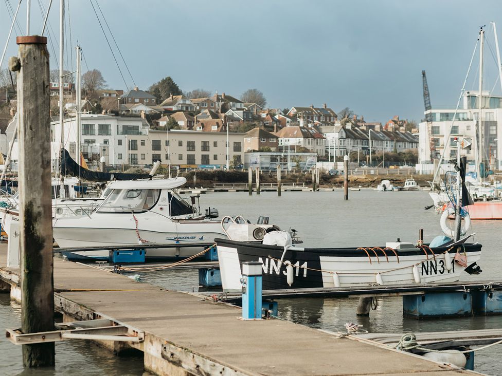 Boats docked at a pier with buildings in the background at 5 Mariners Wharf Newhaven