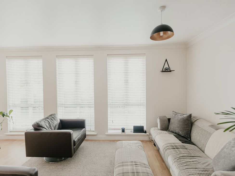 A living room with couches and windows at 5 Mariners Wharf in Newhaven