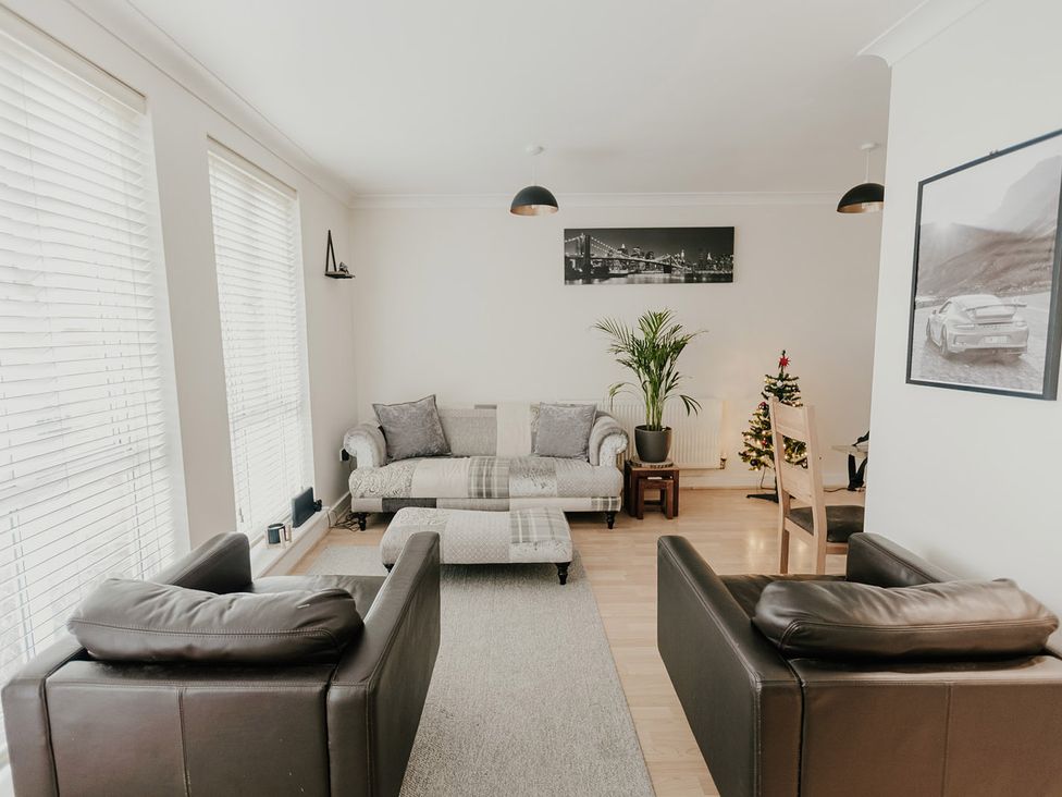A living room with sofa and armchairs at 5 Mariners Wharf Newhaven