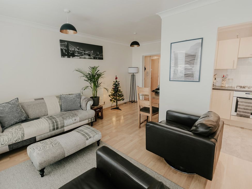 A living room with a sofa and a Christmas tree at 5 Mariners Wharf Newhaven