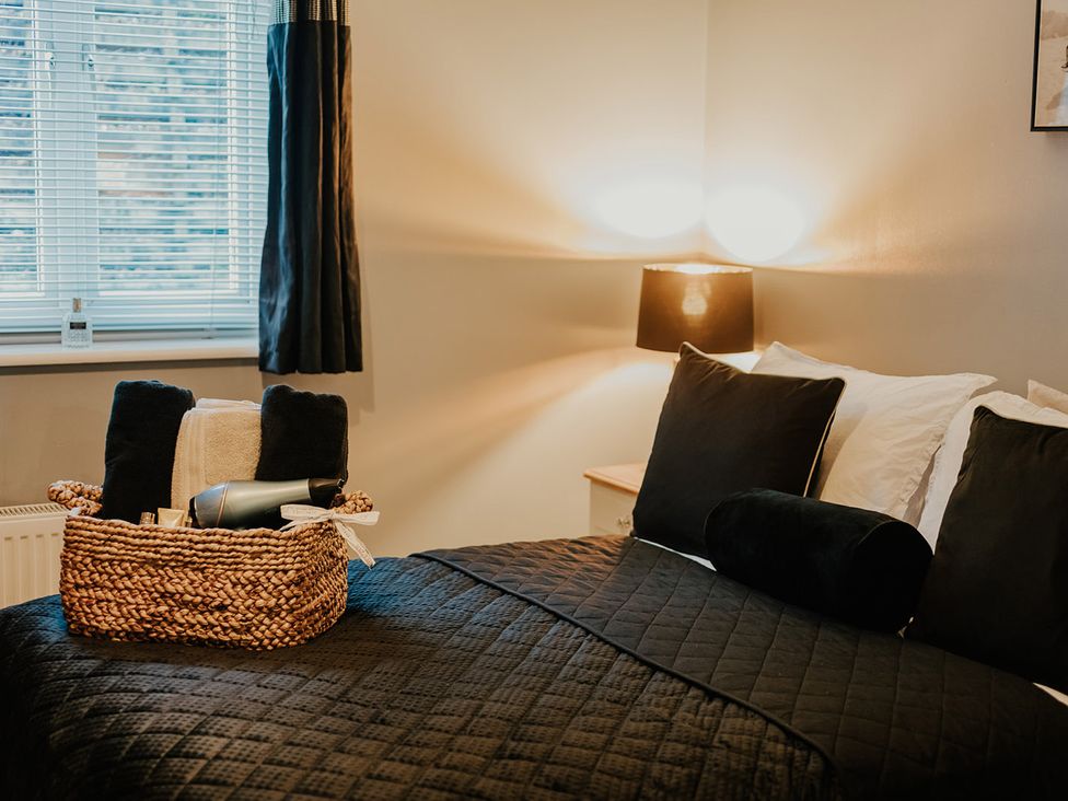 A bedroom with a bed and a basket at 5 Mariners Wharf Newhaven
