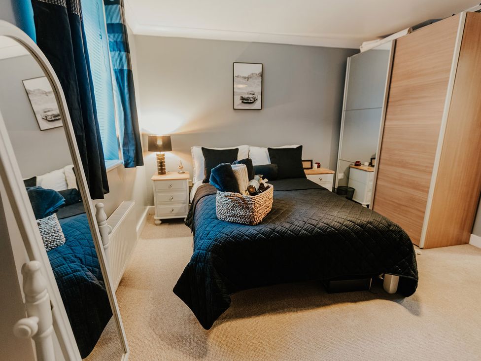 A bedroom with a bed and a wardrobe at 5 Mariners Wharf in Newhaven