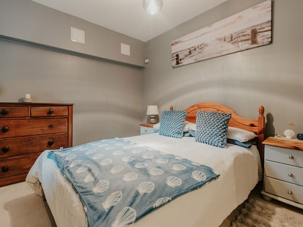 A bedroom with a bed and dresser at 5 Mariners Wharf Newhaven