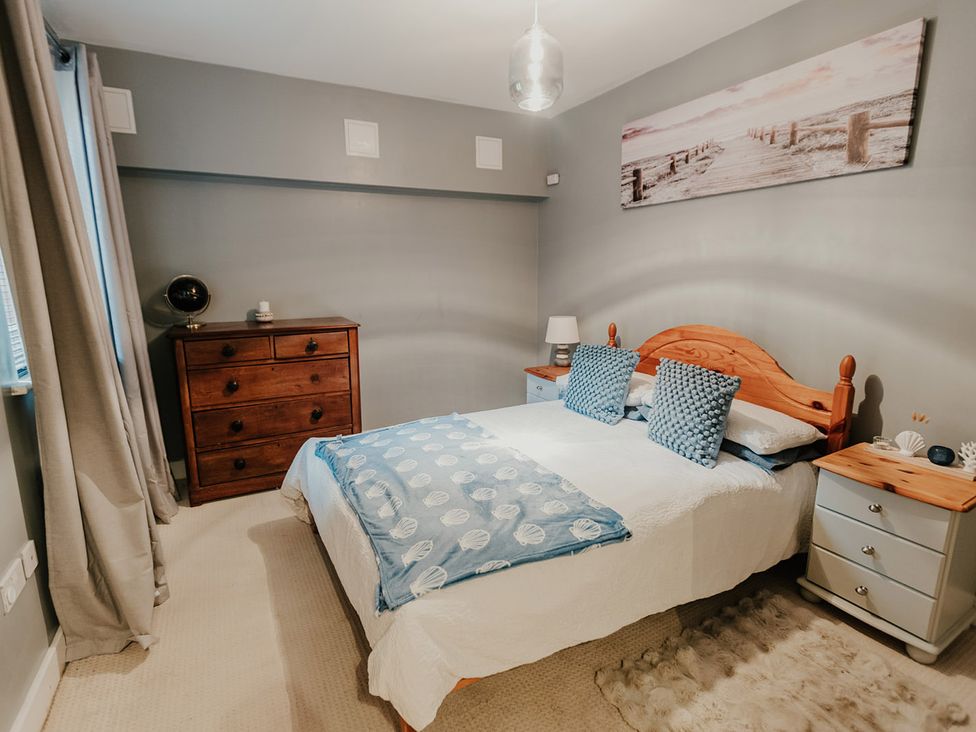 A bedroom with a bed and dresser at 5 Mariners Wharf Newhaven