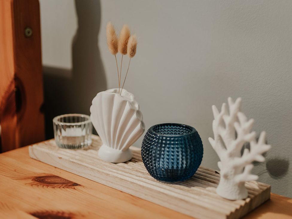 A decorative arrangement of vases and holders on a wooden tray at 5 Mariners Wharf, Newhaven