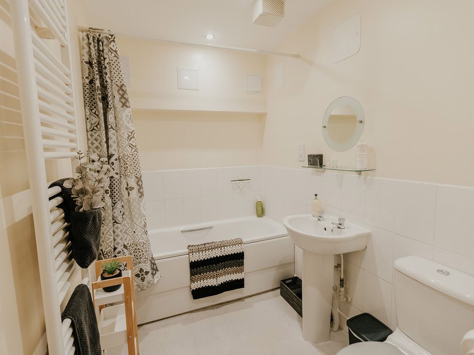 A bathroom with a bathtub, sink, and toilet at 5 Mariners Wharf Newhaven