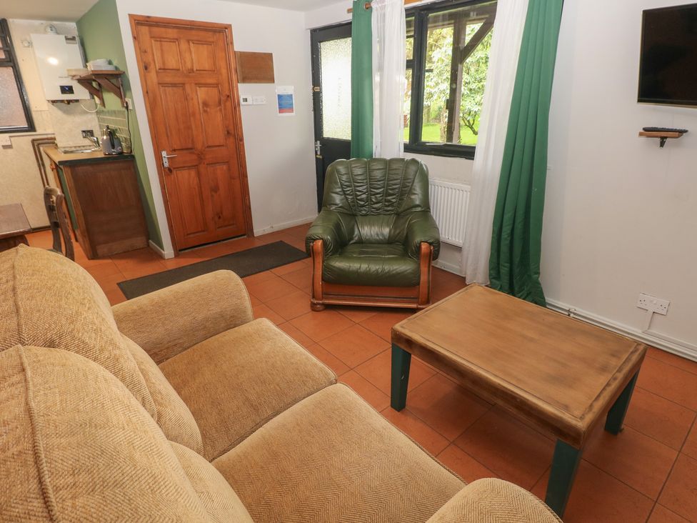 A living room with a couch and an armchair at Cabin No. 2 - Salt and Fern Cabins Goytre near Port Talbot