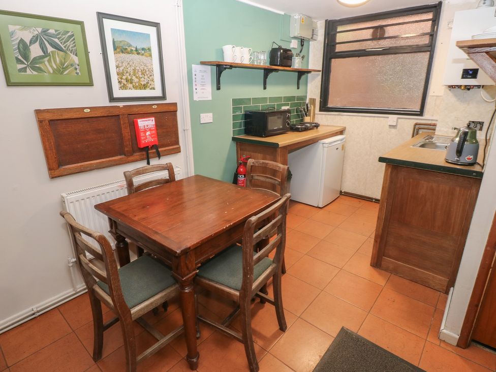A kitchen with a table and chairs at Cabin No. 2 - Salt and Fern Cabins Goytre near Port Talbot