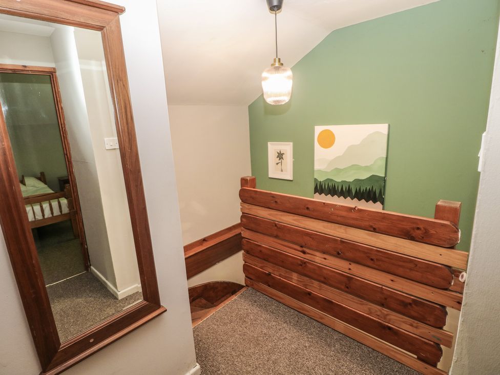 A hallway with a staircase and artwork at Cabin No. 2 - Salt and Fern Cabins near Goytre Port Talbot