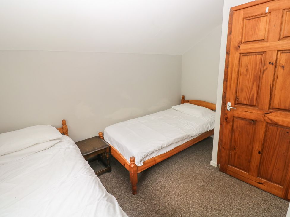 A bedroom with two beds and a door at Cabin No. 2 - Salt and Fern Cabins in Goytre near Port Talbot