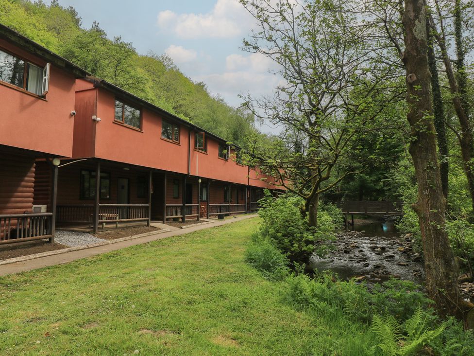 Cabins along a pathway with a stream at Cabin No. 2 - Salt and Fern Cabins in Goytre near Port Talbot