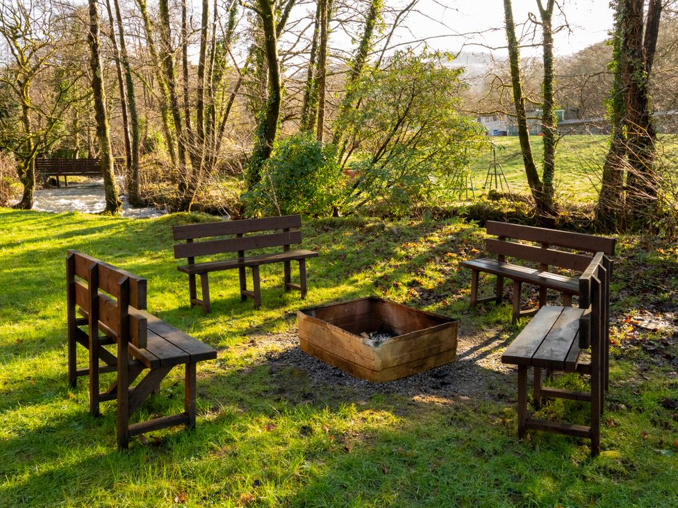 An outdoor area with a fire pit and wooden benches at a property