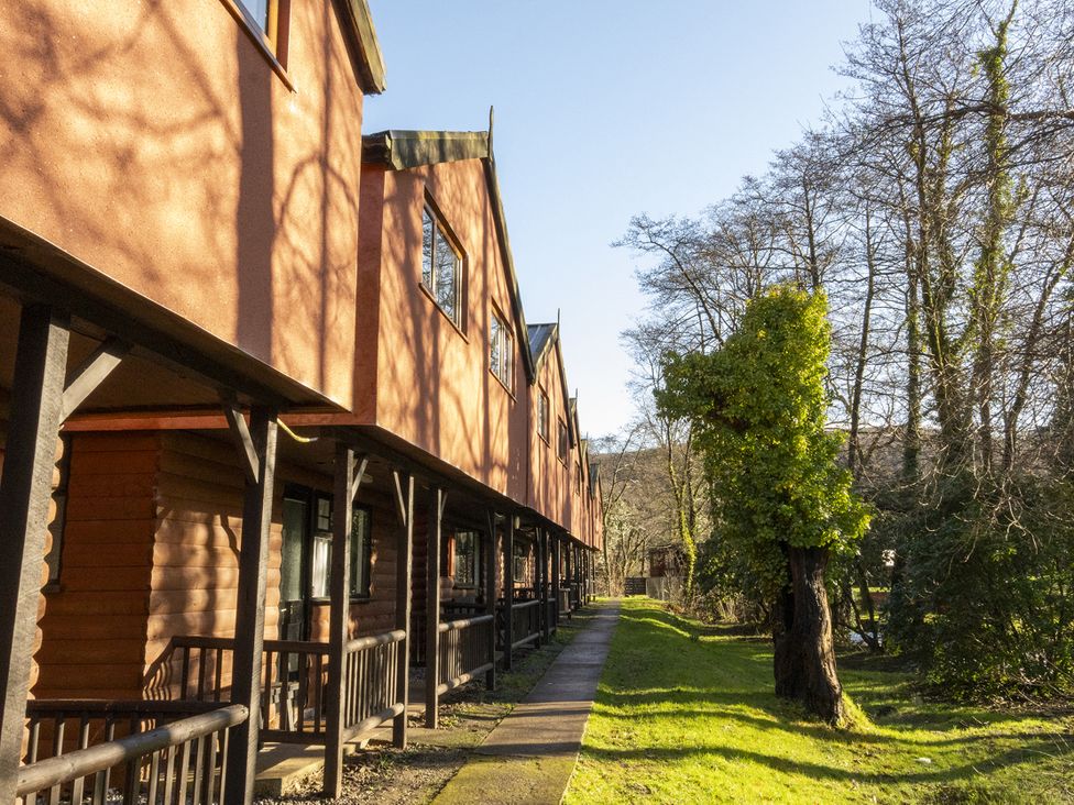A row of buildings with a pathway and trees at 3-bedroom cabin (3 of 13) Port Talbot