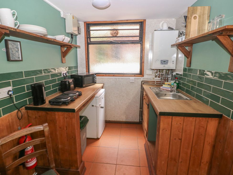 A kitchen with a sink and stove at Cabin No. 3 - Salt and Fern Cabins Goytre near Port Talbot