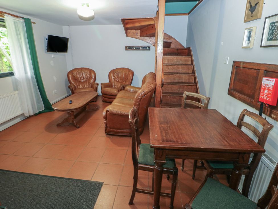 A living room with a sofa and dining table at Cabin No. 3 - Salt and Fern Cabins Goytre near Port Talbot