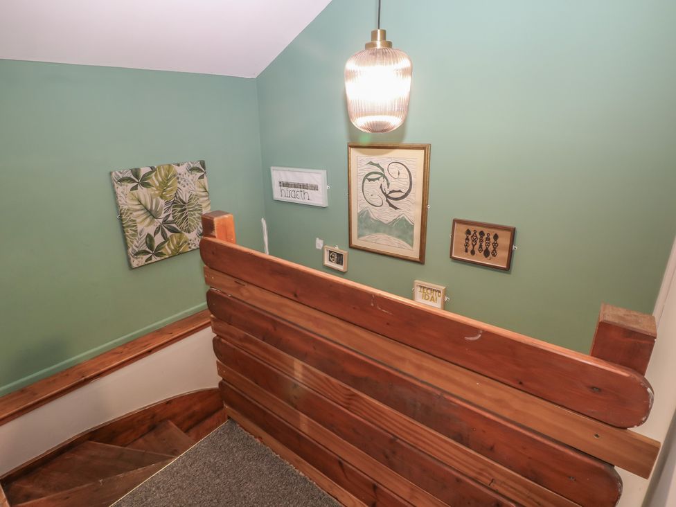 A staircase with wall art and a light fixture at Cabin No. 3 - Salt and Fern Cabins Goytre near Port Talbot