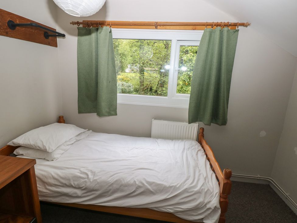 A bedroom with a bed and a window at Cabin No. 3 - Salt and Fern Cabins, Goytre near Port Talbot