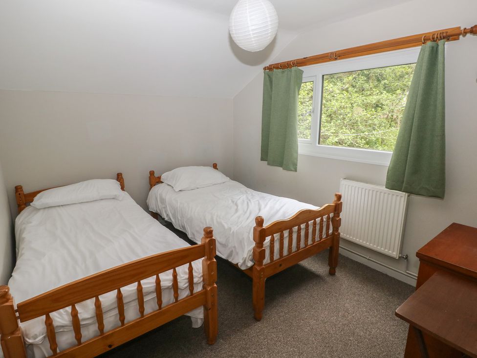 A bedroom with twin beds and curtains at Cabin No. 3 - Salt and Fern Cabins Goytre near Port Talbot