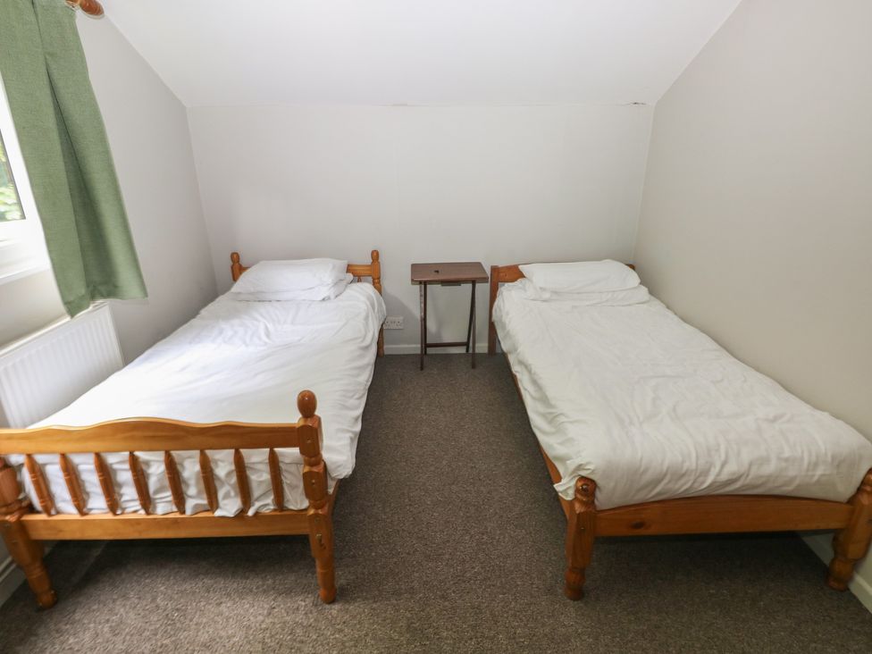 A bedroom with two single beds and a table at Cabin No. 3 - Salt and Fern Cabins in Goytre near Port Talbot