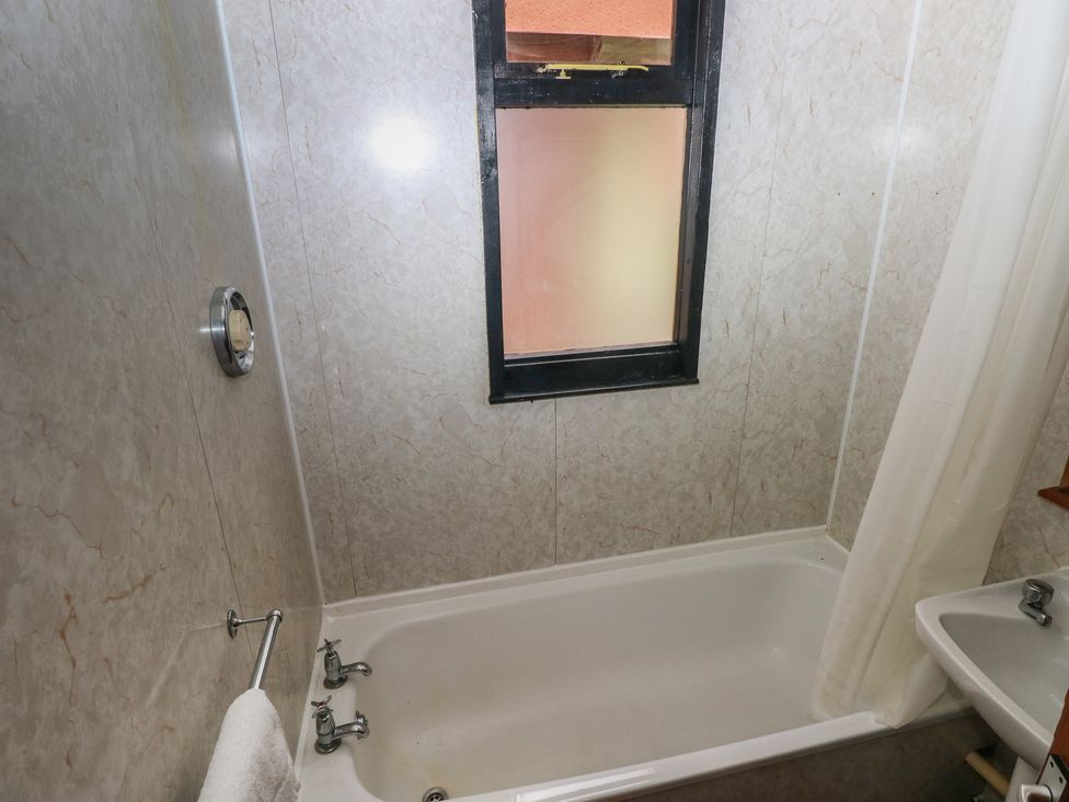 A bathroom with a bathtub and sink at Cabin No. 3 - Salt and Fern Cabins Goytre near Port Talbot