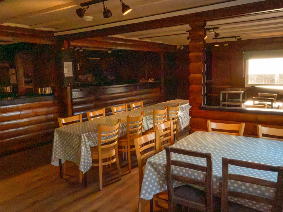A dining room with tables and chairs at 3-bedroom Cabin (4 of 13) Port Talbot